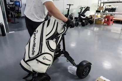 Person zieht den GOOTER E-CadPro mit Golfbag im Innenbereich